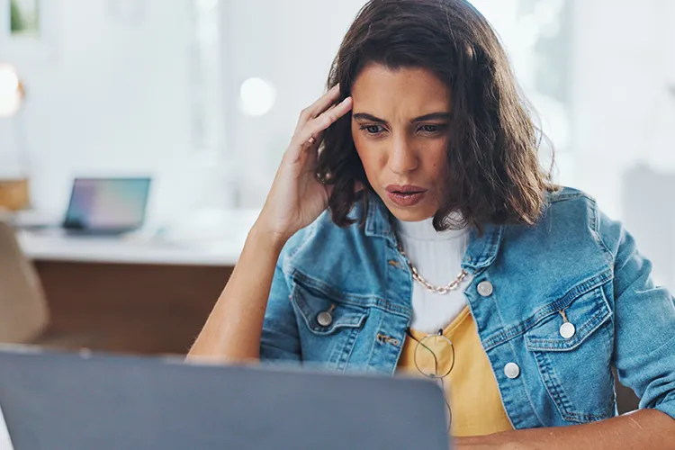 Woman confused looking at laptop